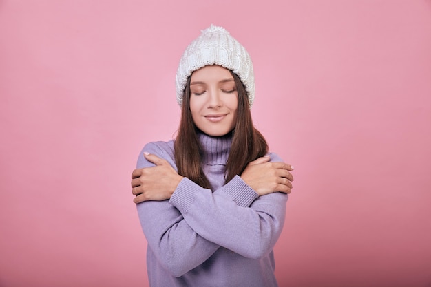 La donna graziosa calma in inverno abbraccia le sue spalle