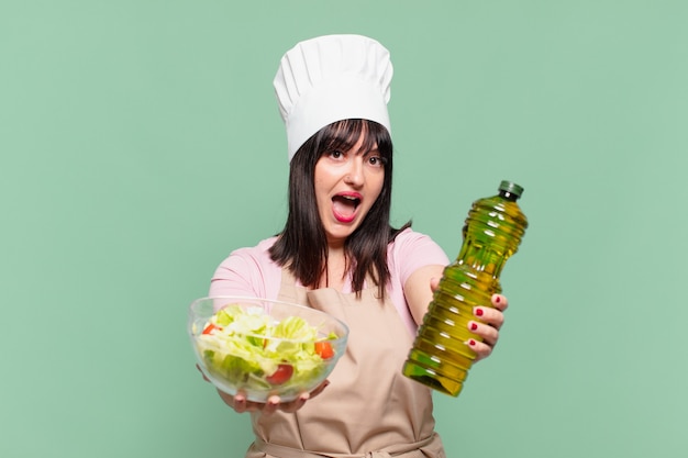 La donna graziosa dello chef ha sorpreso l'espressione e con in mano un'insalata?