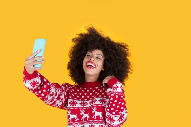 La donna graziosa fa il selfie dallo smartphone a natale