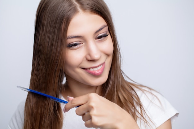 La donna graziosa si pettina i capelli a casa