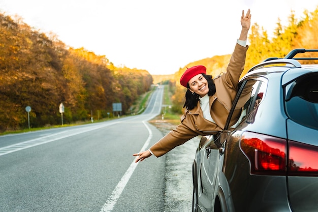 la donna guarda fuori dal finestrino dell'auto parcheggiata in autunno