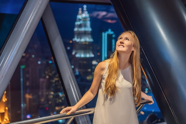 La donna guarda il paesaggio urbano di Kuala Lumpur Vista panoramica dello skyline della città di Kuala Lumpur sera al tramonto grattacieli in Malesia