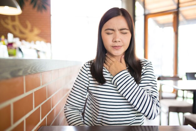 La donna ha mal di gola nel caffè