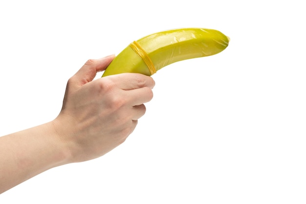 La donna ha messo un preservativo su una banana isolata su sfondo bianco