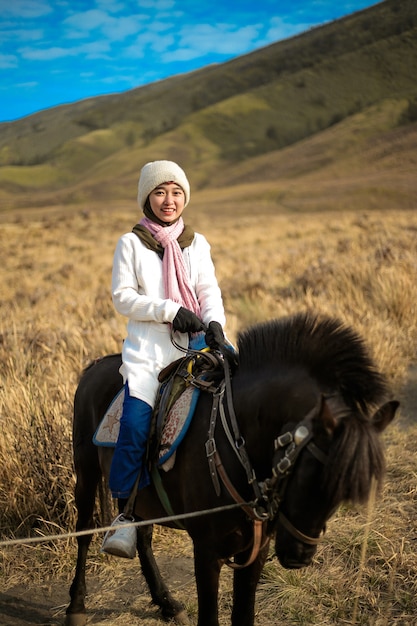 La donna Hijab cavalca un cavallo a Bromo East Java