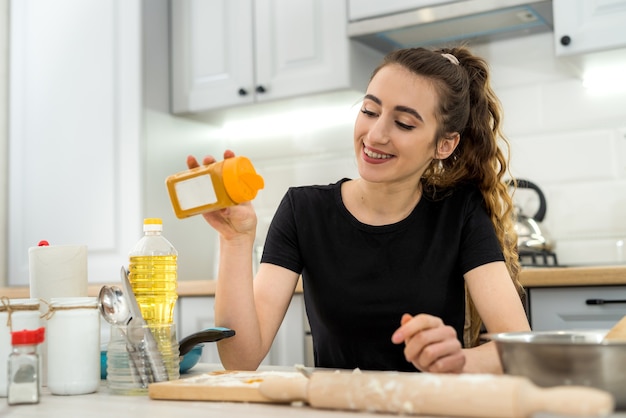 La donna impasta la pasta con un ingrediente diverso. Alimento sano della famiglia