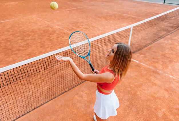 La donna in abiti sportivi gioca a tennis in competizione