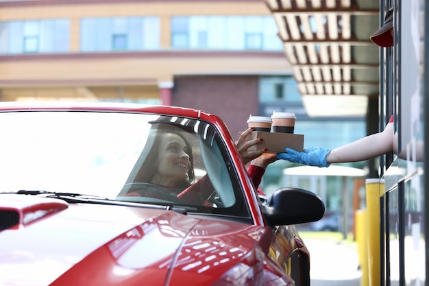 La donna in automobile prende il suo concetto del caffè