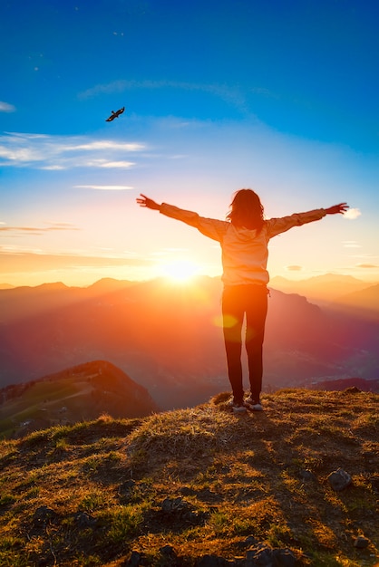 La donna in cima ad una montagna al tramonto sembra l'aquila