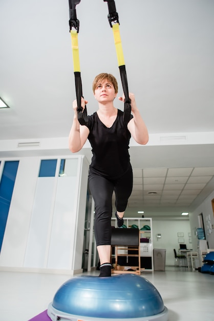La donna in forma atletica fa esercizio TRX