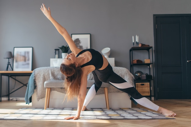 La donna in forma si allena a casa, facendo backbend.