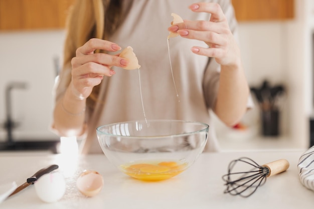 La donna in pigiama sta preparando la colazione a base di uova in cucina a casa