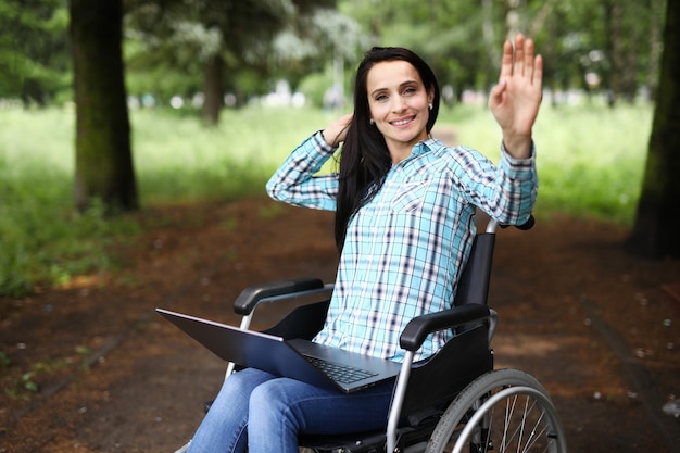 La donna in sedia a rotelle agita la mano in segno di saluto