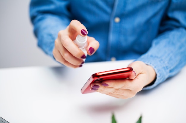 La donna in ufficio usa l'antisettico per la disinfezione.