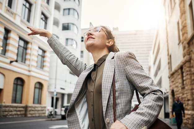 La donna in viaggio in città e ferma il taxi si reca al lavoro con edifici professionali e trasporti all'aperto Persona di sesso femminile aziendale in abiti da lavoro di strada urbana e viaggio verso il posto di lavoro