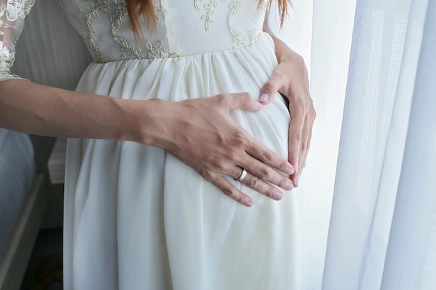 La donna incinta che tiene il suo stomaco irregolare, sente il suo bambino