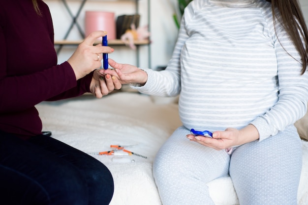 La donna incinta controlla la glicemia, test del diabete.