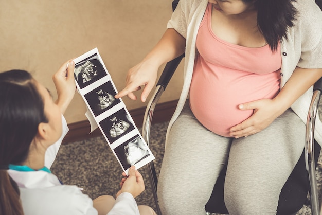 La donna incinta felice visita il medico ginecologo all'ospedale