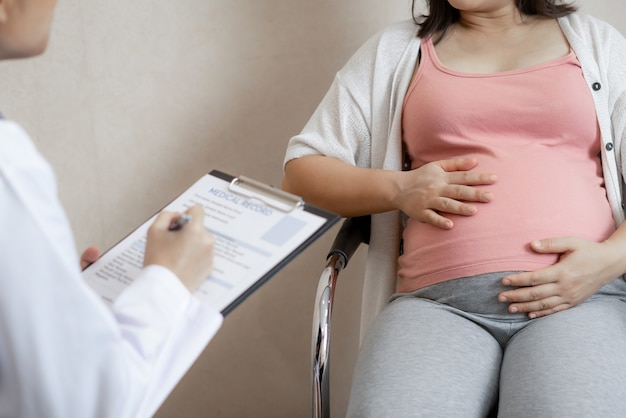 La donna incinta felice visita il medico ginecologo all'ospedale