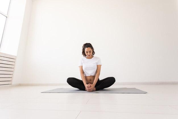 La donna incinta intenzionale si esercita durante la lezione di yoga e si rilassa stando seduti su una stuoia sul