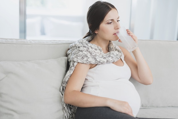 La donna incinta malata beve la compressa sciolta in acqua.