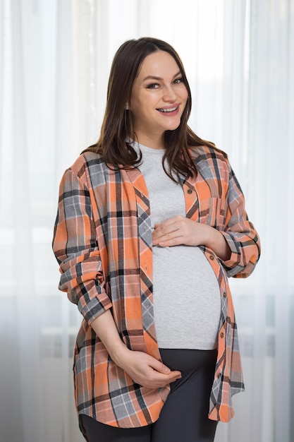 La donna incinta mostra la pancia in attesa della nascita del bambino