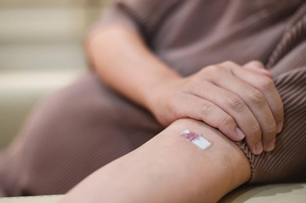 La donna incinta preleva il sangue da una ferita da iniezione sul braccio di un paziente.