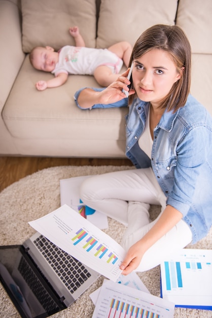 La donna lavora a casa mentre il suo bambino dorme.