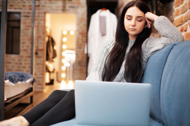 La donna lavora a casa su un laptop durante un'epidemia di virus in tutto il mondo