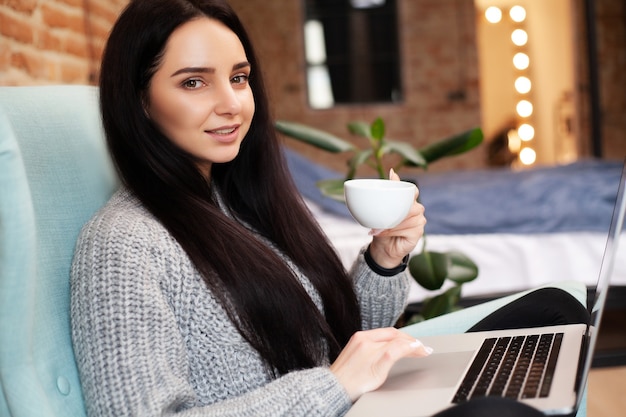 La donna lavora a casa su un laptop durante un'epidemia di virus in tutto il mondo.