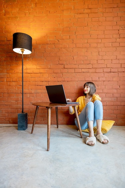 La donna lavora al computer portatile a casa