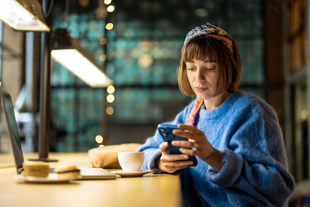 La donna lavora al computer portatile alla caffetteria