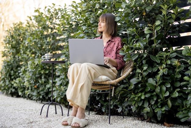 La donna lavora al computer portatile in giardino