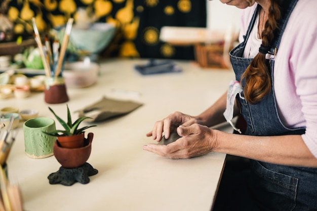 La donna lavora in uno studio di ceramica creativa con argilla Concetto di artigianato fatto a mano