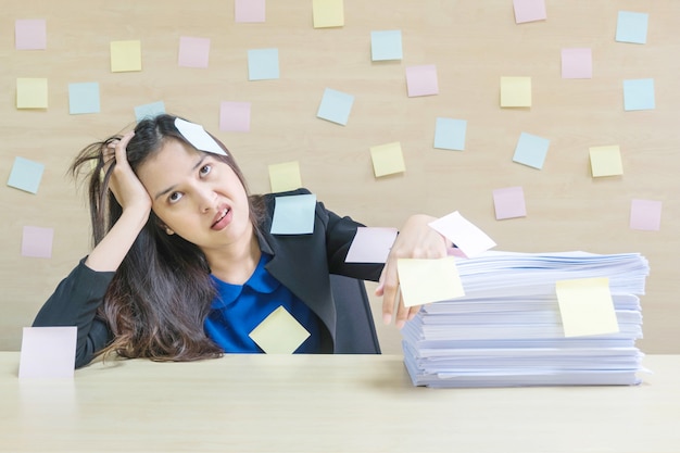 La donna lavoratrice del primo piano ha annoiato dal mucchio di duro lavoro