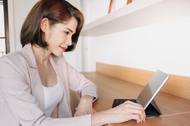 La donna lavoratrice felice sta usando un tablet in ufficio