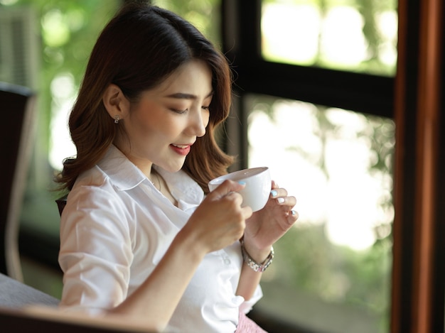 la donna lavoratrice si gode il caffè al bar sorseggiando il caffè mattutino sfocatura sfondo bokeh