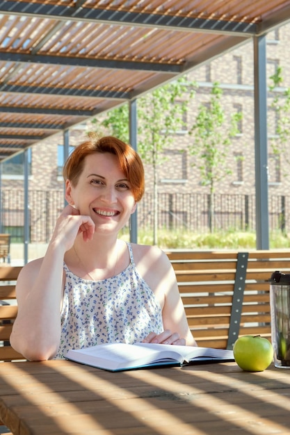 La donna legge un libro vicino all'ufficio durante una pausa di lavoro