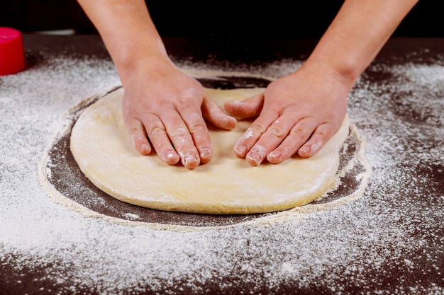 La donna leviga la pasta di lievito con le sue mani