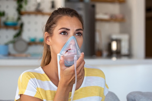 La donna malata che fa la medicina per inalazione è la migliore medicina Donna malata che indossa una maschera di ossigeno e si sottopone a cure per covid19 Donna con un inalatore