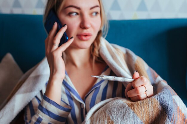 La donna malata guarda il termometro