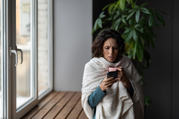 La donna malata si consulta con il medico online utilizzando l'app per smartphone soffre di virus influenzale e febbre