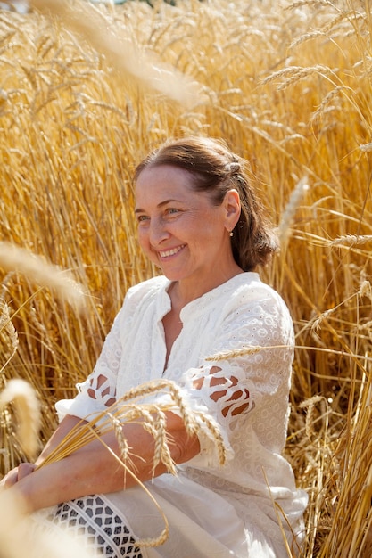 La donna matura di bellezza sola cammina sul photoxDxA orizzontale del campo di grano