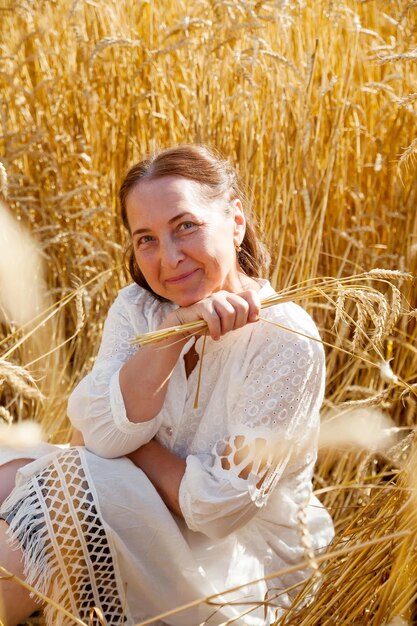 La donna matura di bellezza sola cammina sul photoxDxA orizzontale del campo di grano