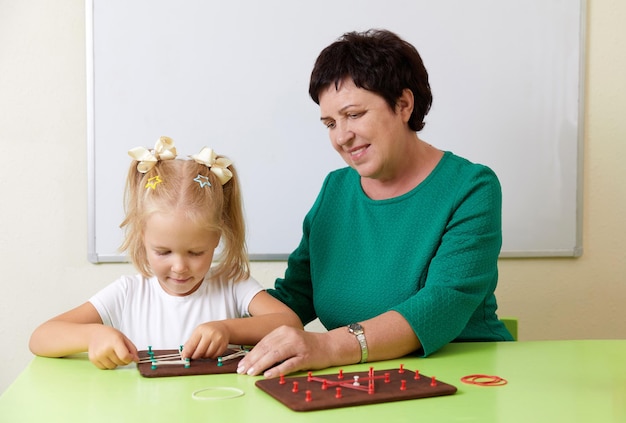 La donna matura insegna al bambino lo sviluppo dell'alfabeto del concetto di abilità motorie fini