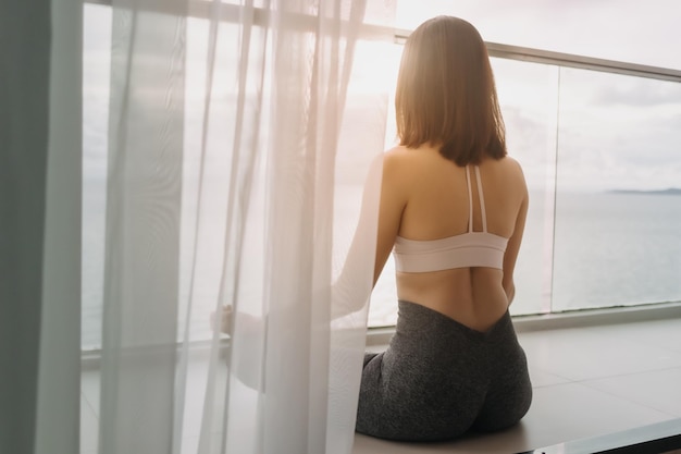 La donna medita l'asana yoga sul balcone al mattino