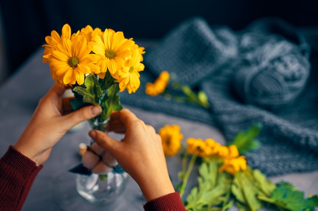 La donna mette i fiori gialli in vaso