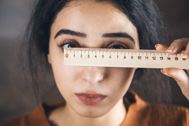 La donna misura gli occhi con un righello