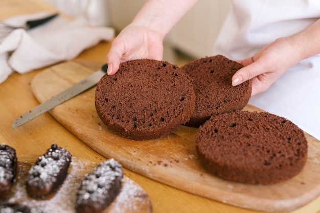 La donna mostra un pan di spagna al cioccolato, elabora una torta da forno