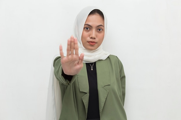 La donna musulmana asiatica hijab mostra il gesto delle mani di arresto
